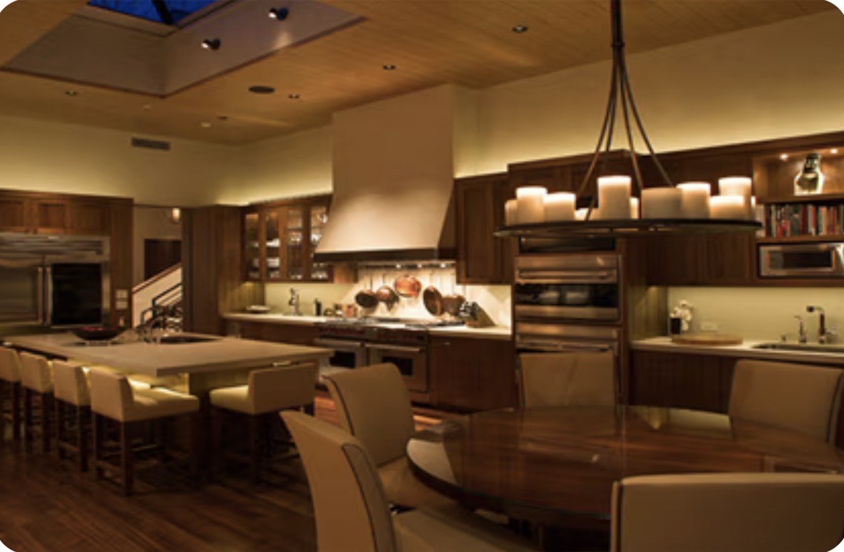 Dark wood kitchen with cove, under-cabinet, and toe-kick light