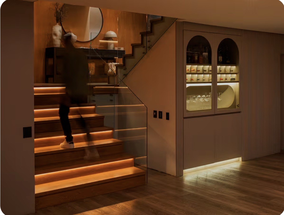 Wood stairs with under-step lights and a lit bar cabinet