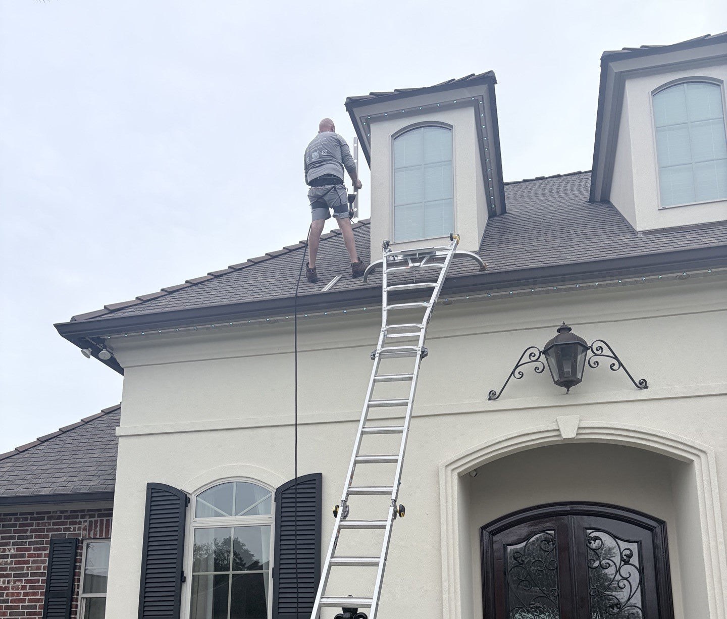 Two-story house with puck lights in track on the eaves