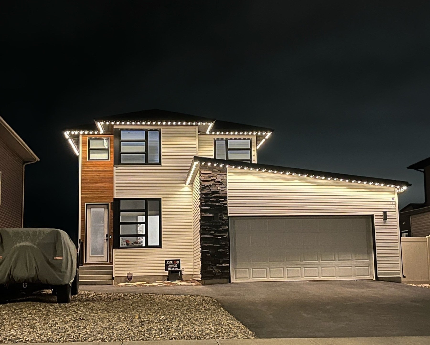 Two-story house with warm white soffit puck lights